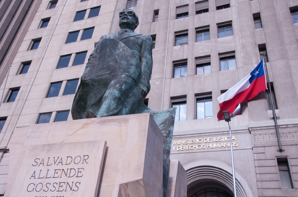 Statue of Salvador Allende Gossens with a chilean flag in Santiago, capital of Chile. In the sign on the back says "Department of Justice and Human Rights".